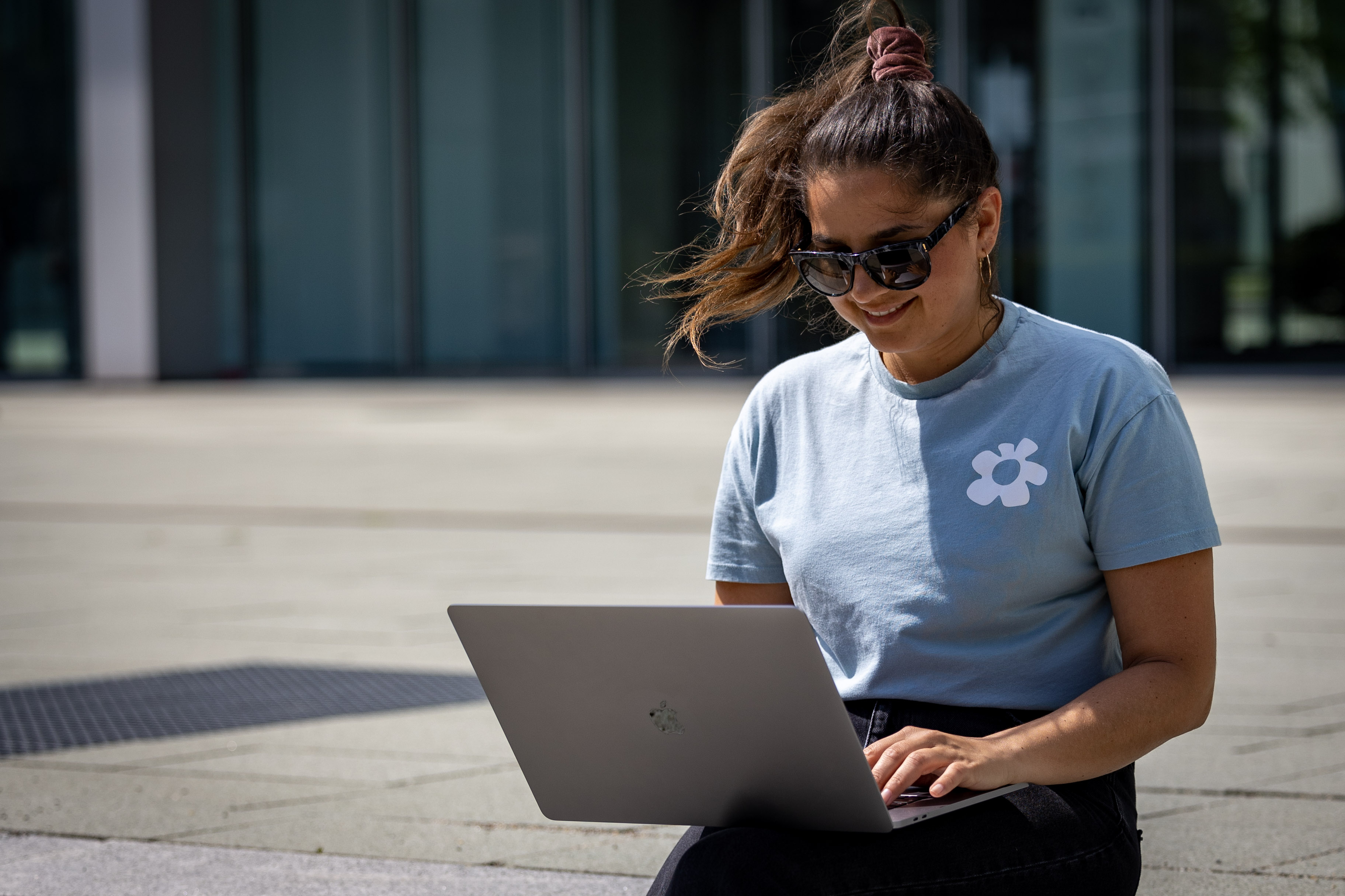 Young woman working with focus on a laptop outdoors