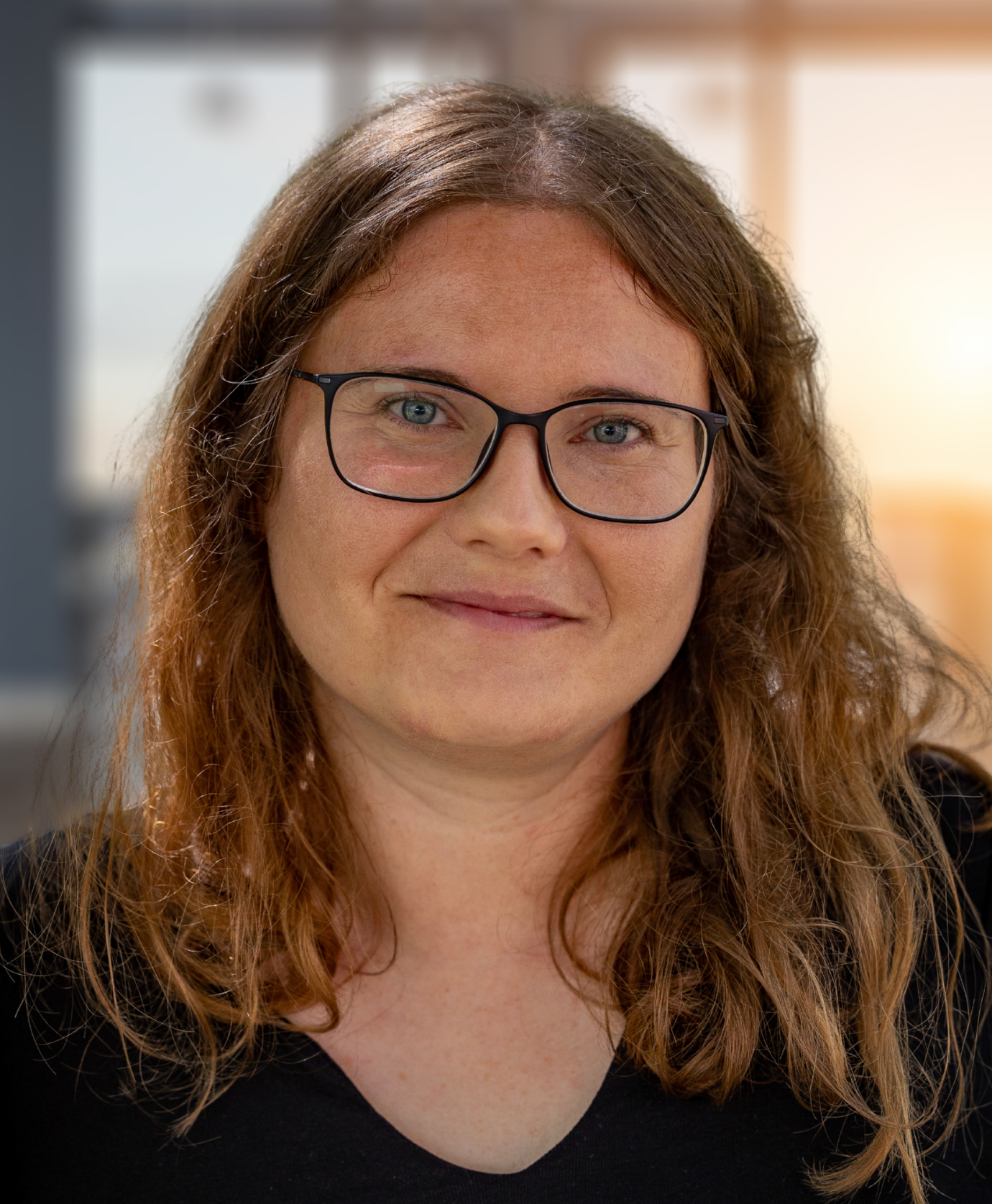 Portrait of a smiling woman with glasses and long hair